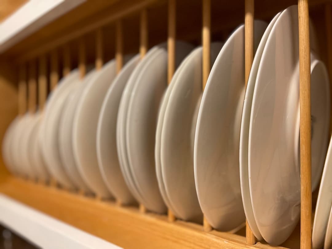 a bunch of white plates that are on a shelf