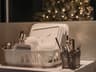 A dish rack with dishes and utensils beside a Christmas tree, creating a warm festive kitchen atmosphere.